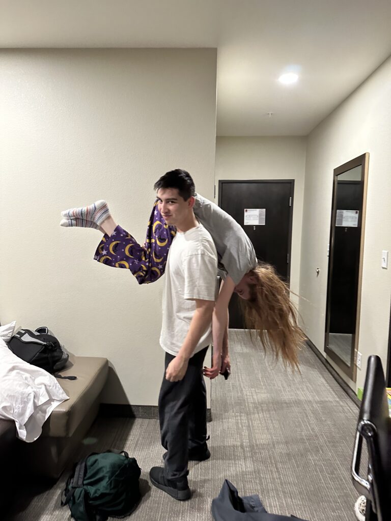 Alix holds Bri slugged over his one shoulder.
