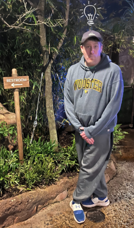 Bri's dad stands in a stereotypical "I need to use the bathroom" pose next to a restroom sign. A lightbulb cartoon is showed over his head.