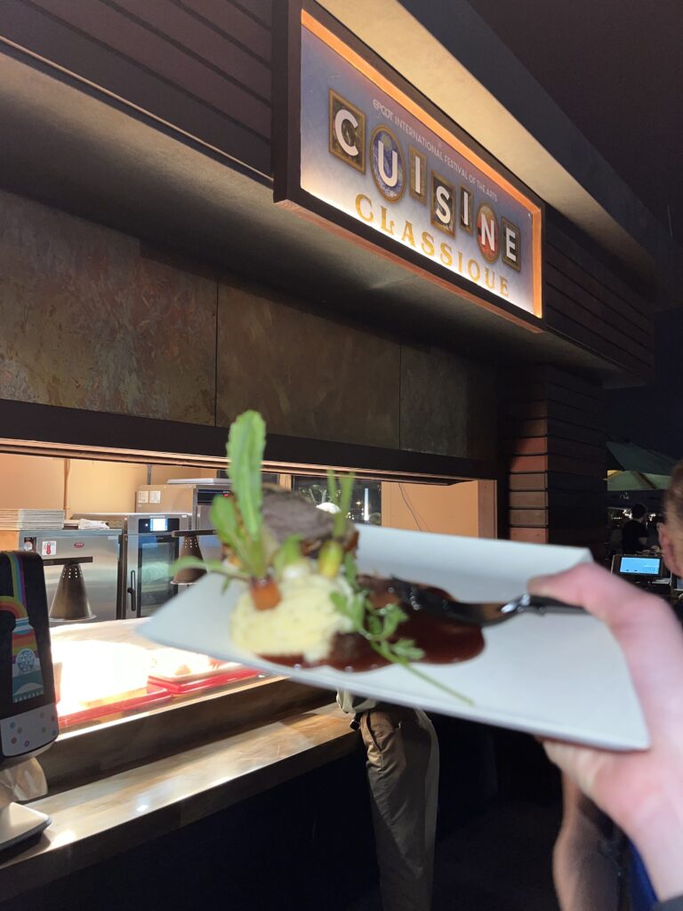 Beef Wellington held up in front of the Classique Cuisine food booth.