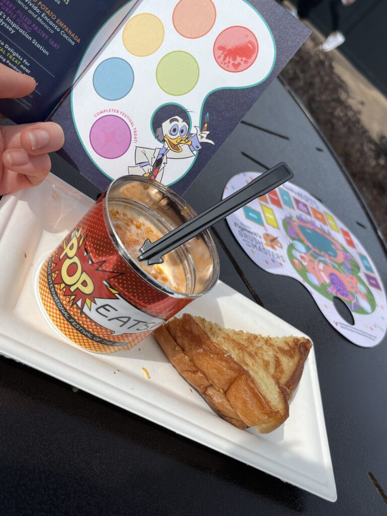 A can of tomato soup that has a label saying "Pop-Eats" on it and a wedge of grilled cheese.