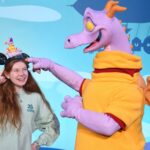 Figment points to Bri's hat where a tiny shoulder magnet pal figment stands.