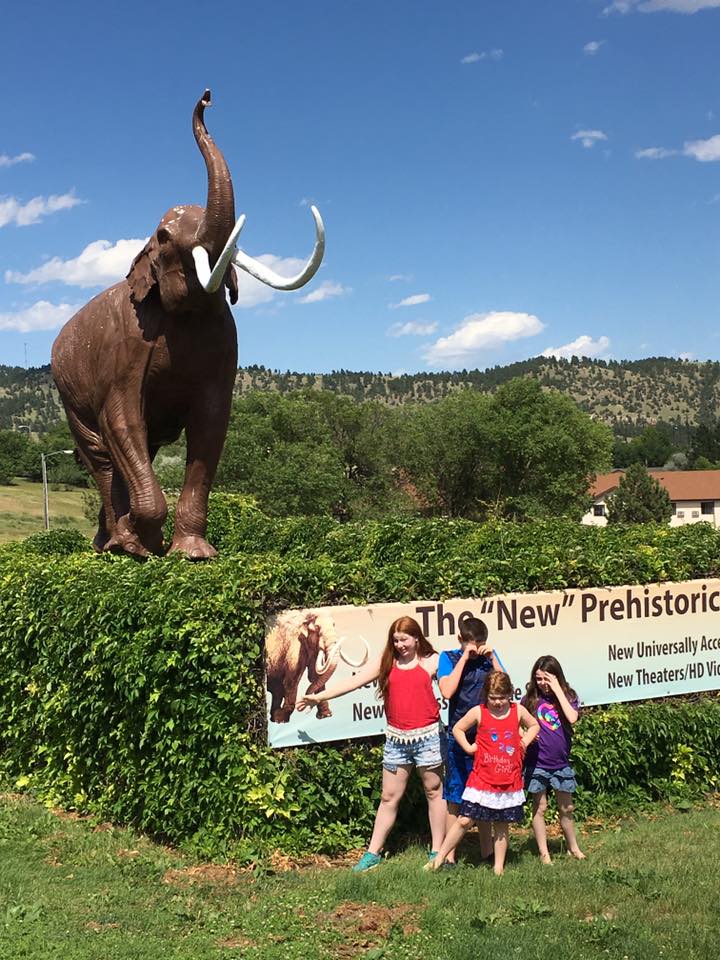 Bri and her 3 siblings are seen in the distance by the sign for Mammoth Cave, SD.