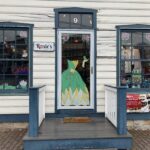 Picture of a store front with a liquid marker Tiana dress drawn on the glass door.