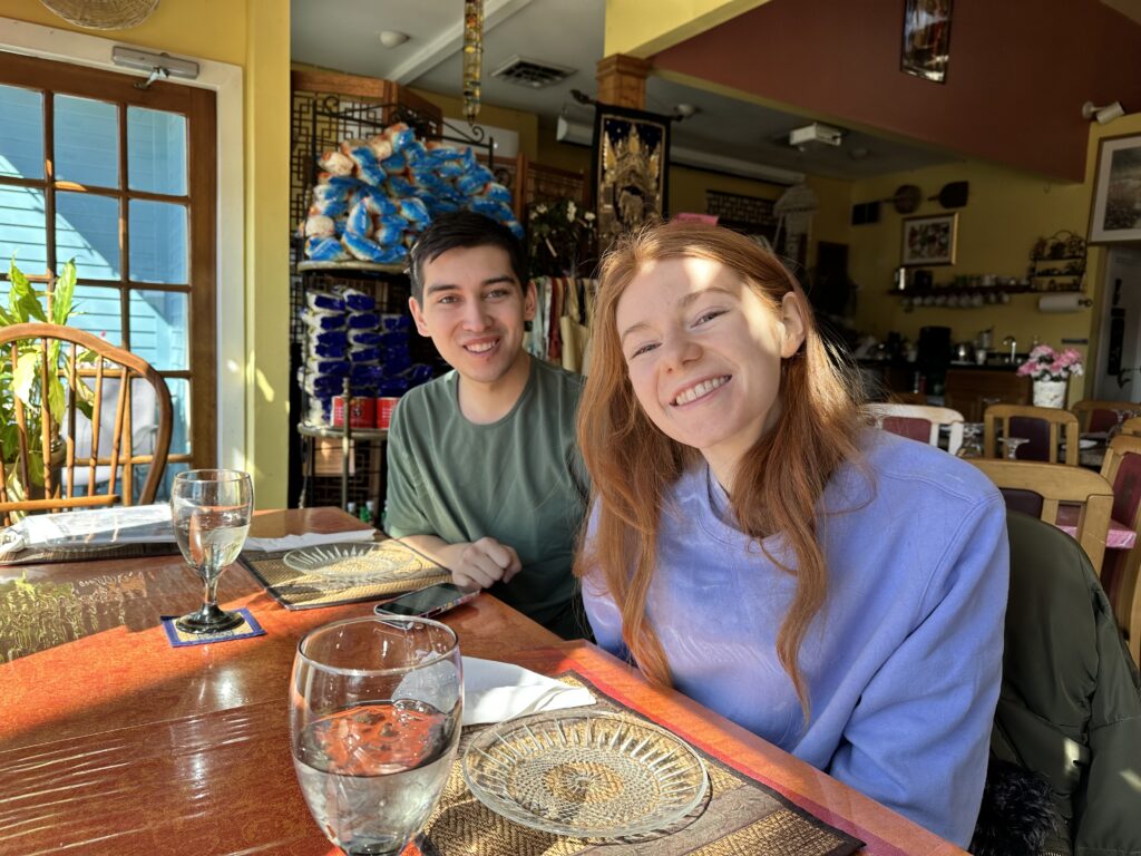 Bri and Alix smile seated together at the table.