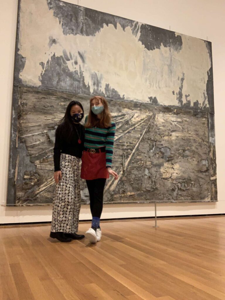Picture of Bri and her friend in front of a big art mural.