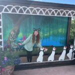 Bri stands by a giant photo frame with Mary Poppin's dancing penguins.
