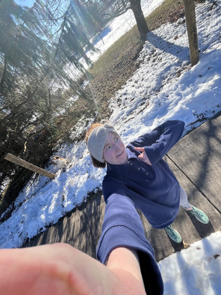 Bri making a nervous face with a thumbs up after finishing a cold winter run.