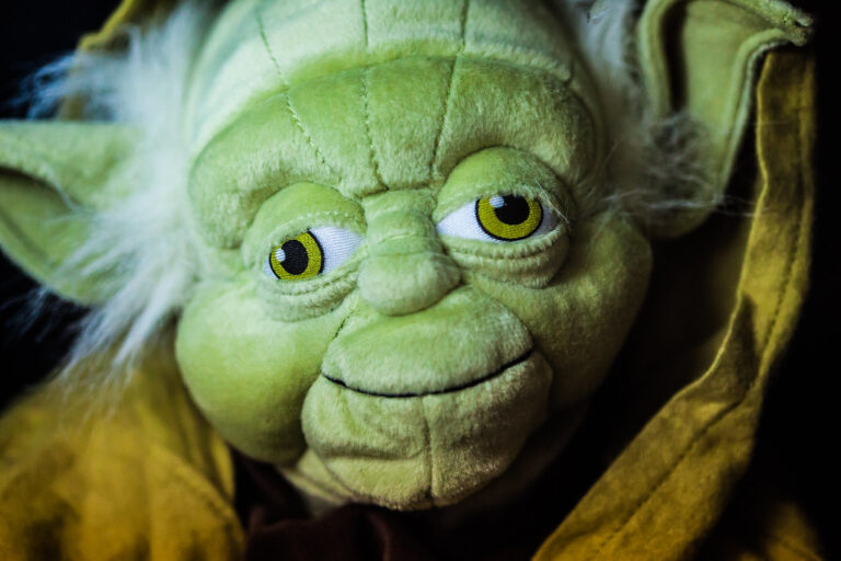 A close-up of a yoda plush with a slightly distorted face