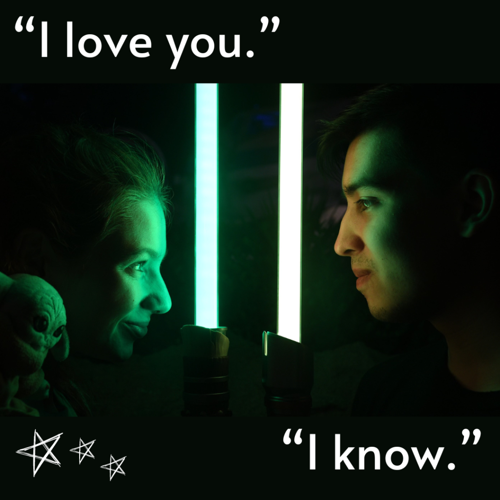 Close up professional photo of Bri and Alix holding lightsabers up close to their face and staring at eachother. The text says "I love you." "I know." with stars in corner.