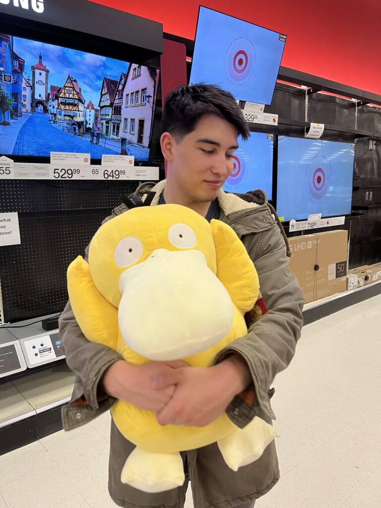 Alix holds a giant Psyduck plush.