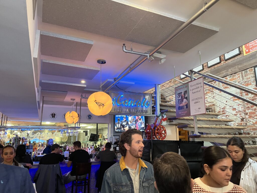 Inside il Canale, lots of people and bright lights in a bustling restaurant.
